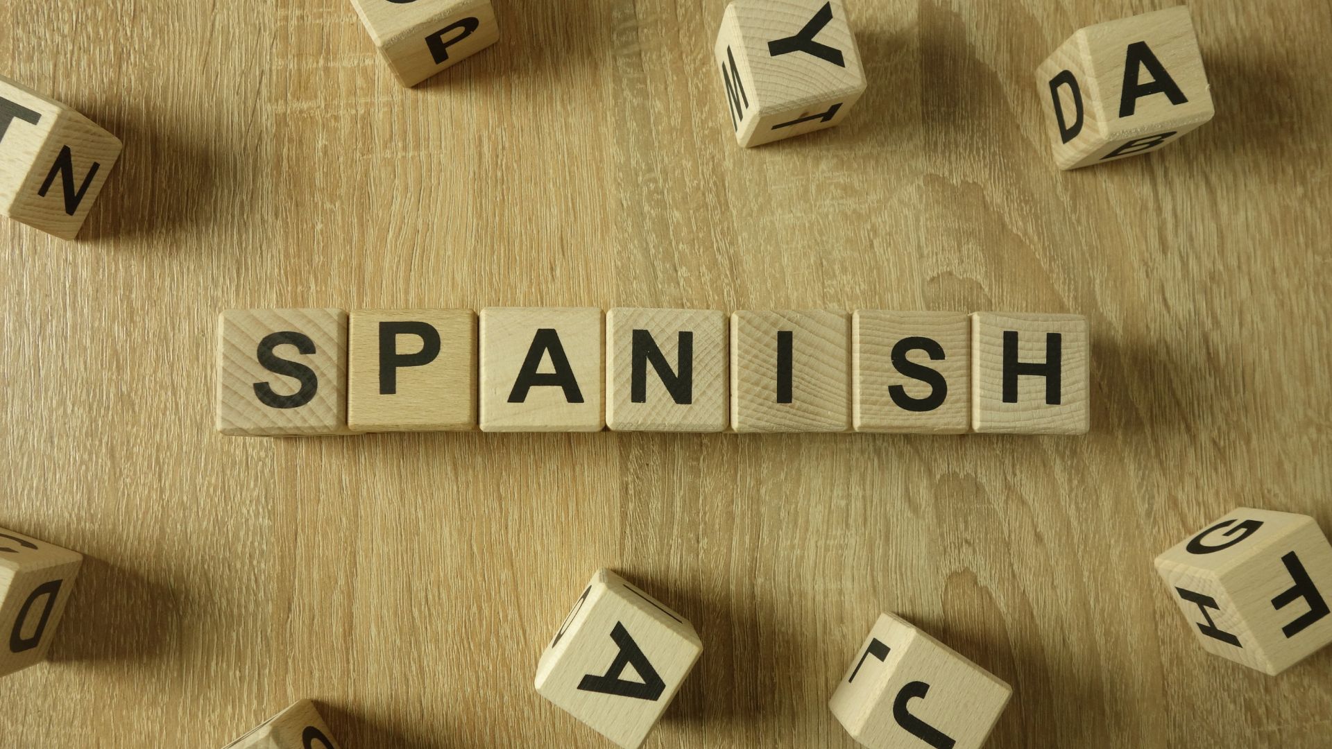 A wooden table topped with blocks spelling out spanish
